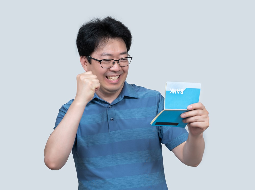 A happy man looking at his bank passbook that yielded hight interest