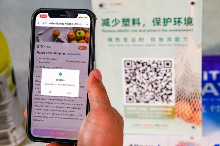 Poster of a mobile phone with an app showing how Alibaba Cloud's sustainability web application can help Asian Games participants adopt low-carbon behaviors