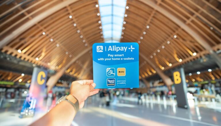A person's hand holding an Alipay+ card