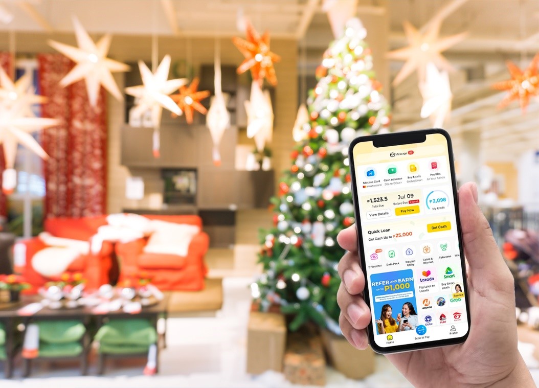 A mobile phone with Mocasa app and a Christmas tree in the background