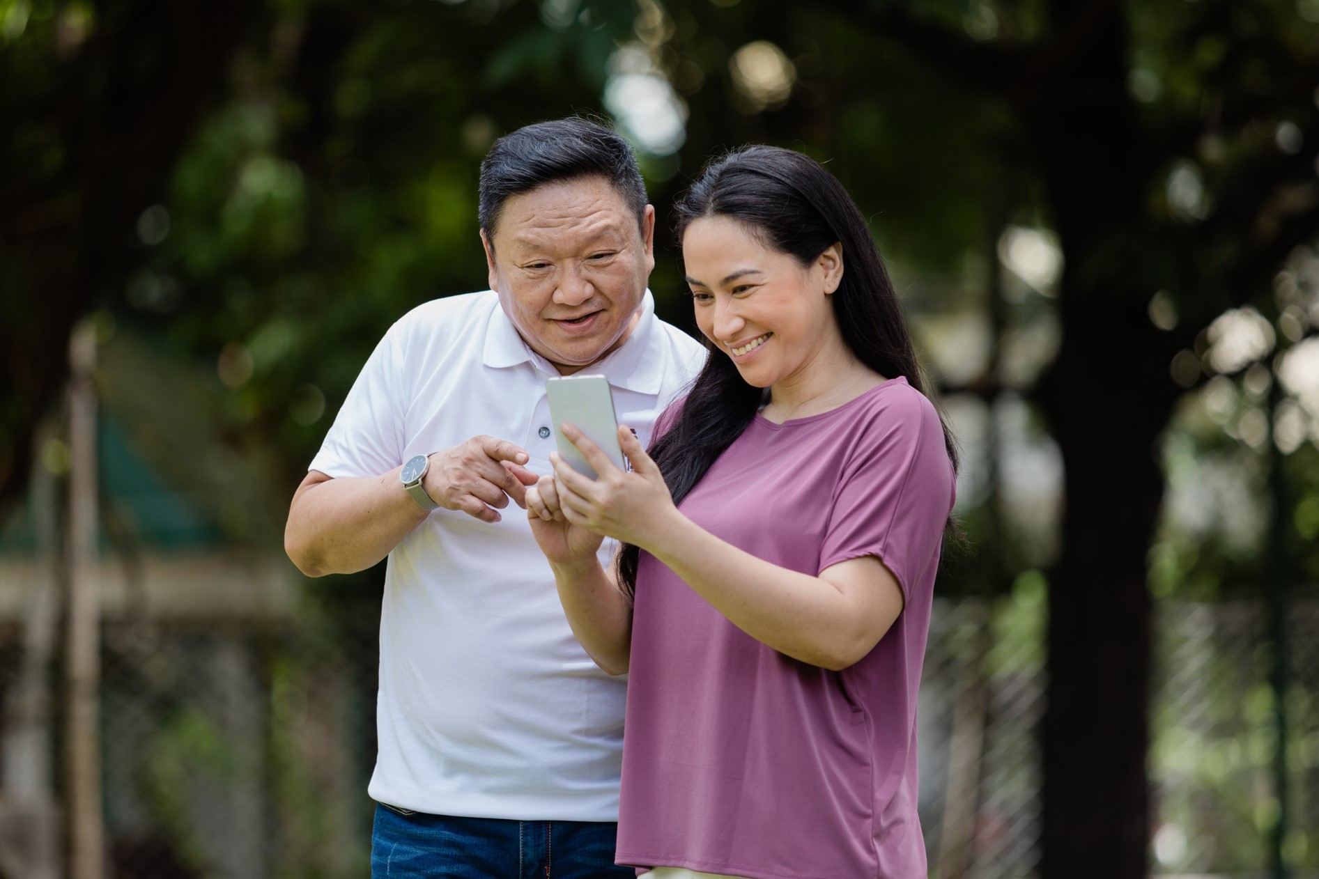 A man and a woman looking at their mobile phone together