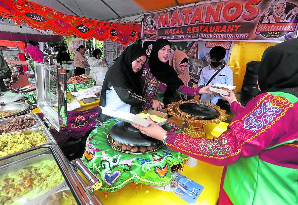 Women clad in their traditional Muslim attire buy goods at a Halal-certified business establishment