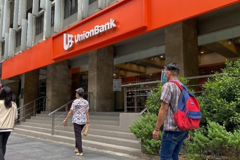 A man walking in front of one of UnionBank's branches in Manila