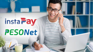 A man holding a mobile phone while making transactions using PESONet and InstaPay