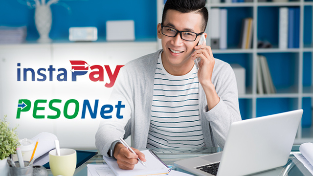 A man holding a mobile phone while making transactions using PESONet and InstaPay