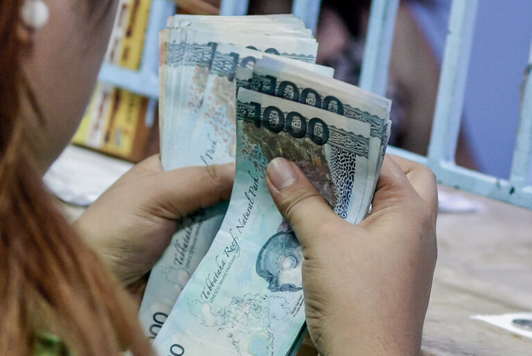 A woman counting bills after coming from a money changer