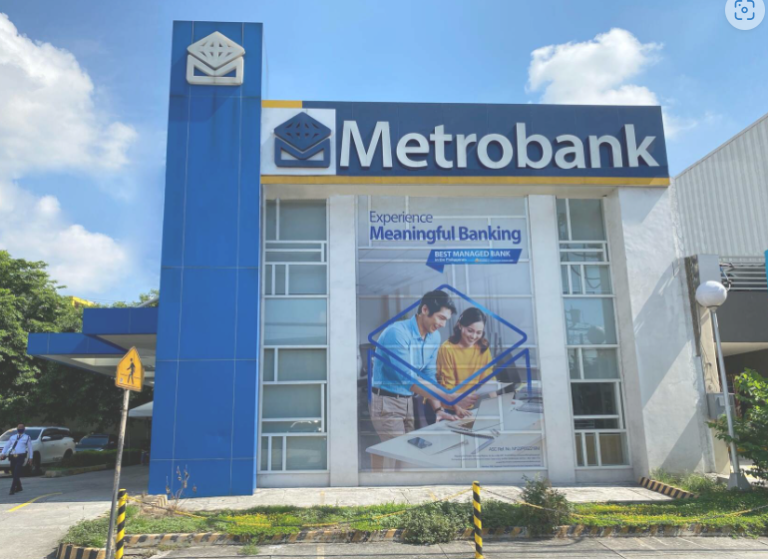 Facade shot of a Metrobank building, with picture of a man and his wife