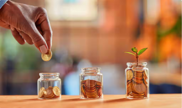 Photo of coins being placed inside bottles to illustrate that the world of investing, and investments, is open to everyone, regardless of their financial background