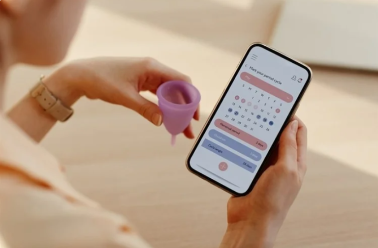 Organon stresses vital role of technology in ensuring women's reproductive health, as can be seen in this photo of a woman holding a mobile phone and a funnel