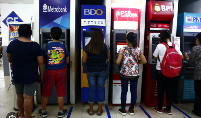 Banking institutions have maintained steady loan standards for businesses and consumers this Q3 2024 as shown in this photo of people lining up in ATMs