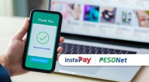 A mobile phone is used to scan a code on a laptop to pay online without reaching InstaPay transfer limits