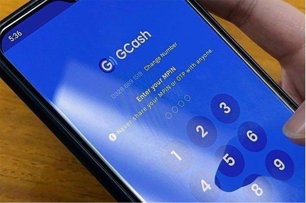 Photo shows a mobile phone with the GCash Cash-in fees app