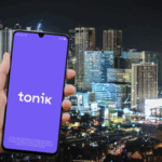 Image of a handheld phone with Tonik logo with financial institutions in the background as the digital bank becomes 1st Philippine company accepted into Tokyo Stock Exchange Asia Startup Hub