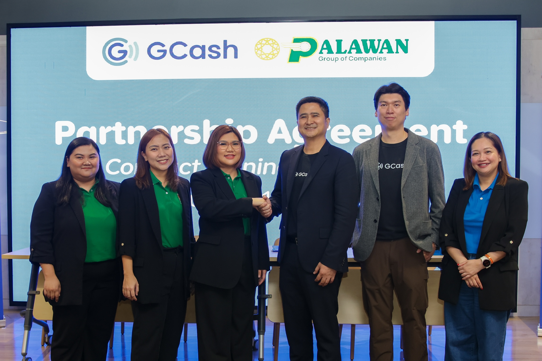 Top executives of Palawan Group of Companies and GCash doing the handshake to formalize the formalize a partnership between the 2 companies