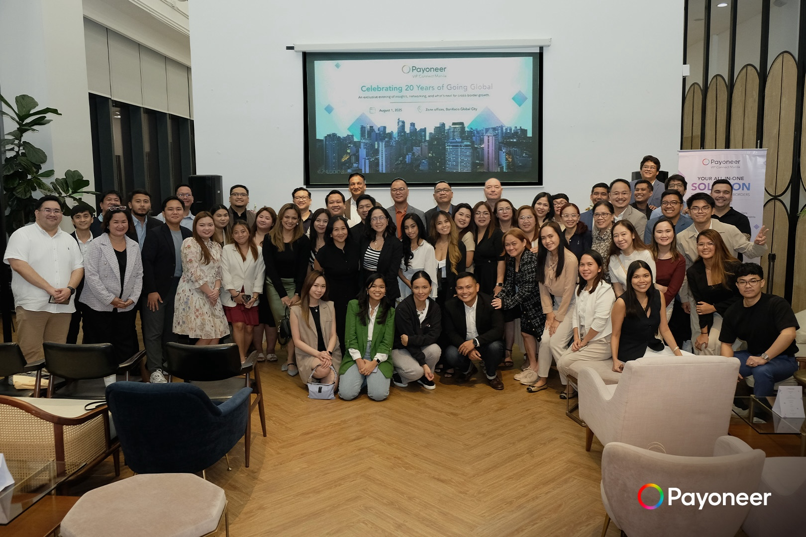 Executives and staff of Payoneer smile for the cameras at a photo shoot during the company's VIP Connect event