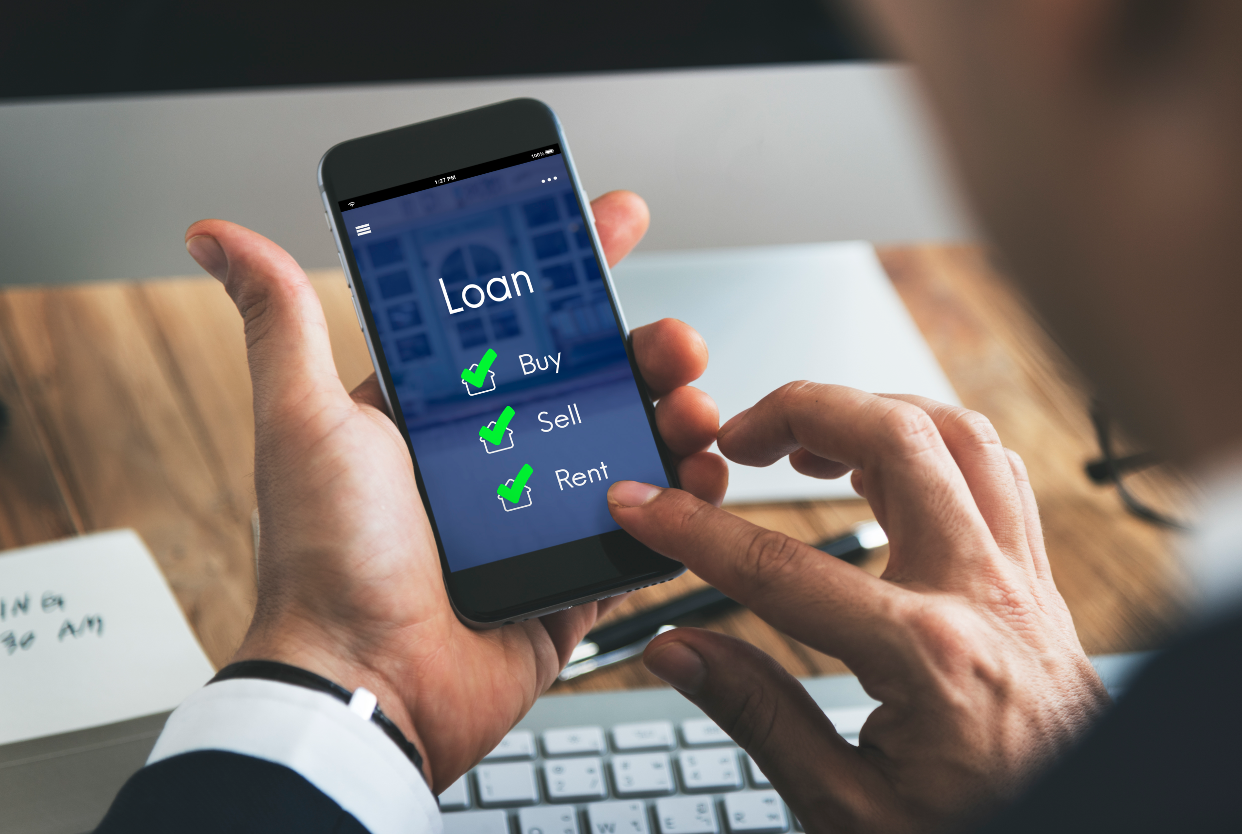 Two hands inputting loan data on a mobile phone as PH digital lending faces crackdown