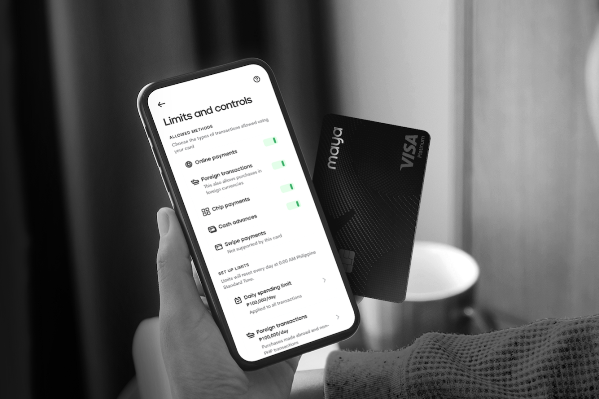 A hand holding a mobile phone with Maya's Black card as the payment company sets new security standards in credit card industry 