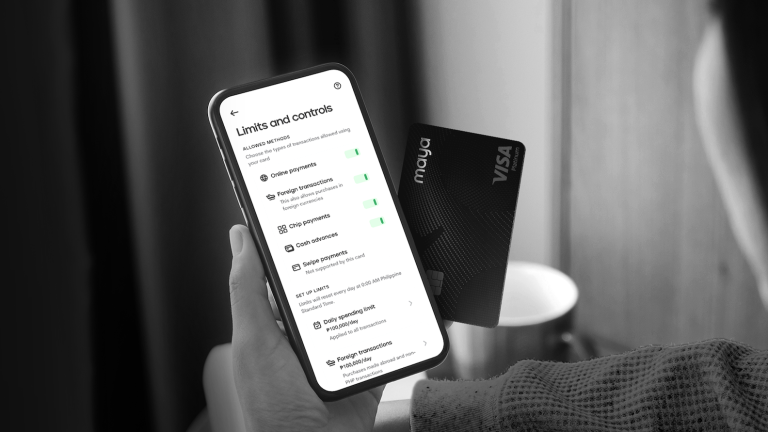 A hand holding a mobile phone with Maya's Black card as the payment company sets new security standards in credit card industry 