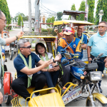 A BSP official, after giving the QR Ph explainer, pays a tricycle driver with GCash fees and Maya card guide