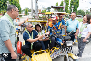 A BSP official, after giving the QR Ph explainer, pays a tricycle driver with GCash fees and Maya card guide