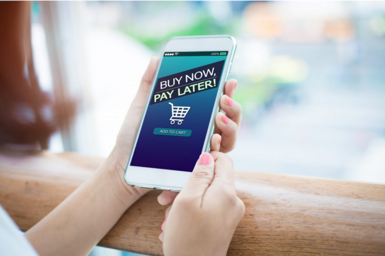 A handheld phone with the words "buy now pay later," a new term that could either be a lifeline or a shortcut to debt