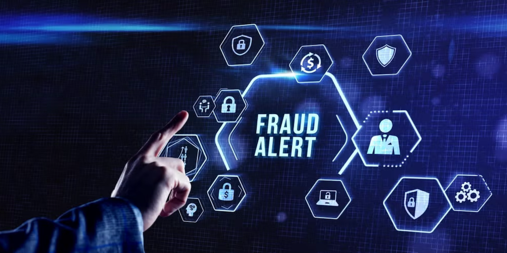 A man touches a screen with the words fraud alert as the country celebrates Cybersecurity Awareness Month