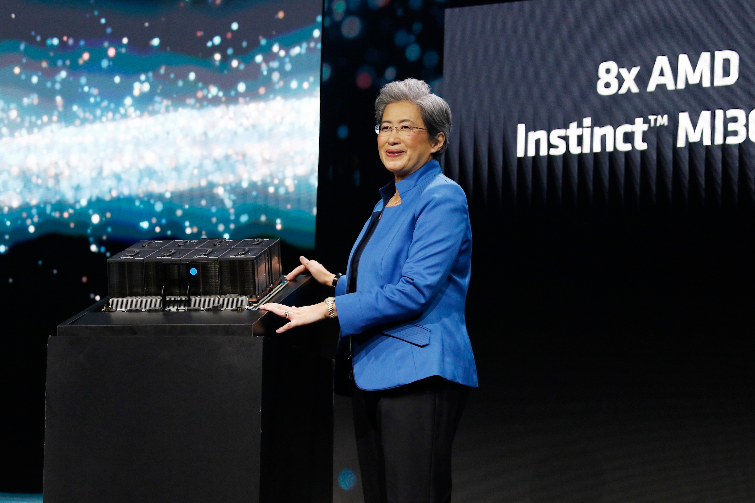 AMD CEO Lisa Su, in blue blazer and near a giant screen, prepares for her talk after being confirmed to deliver the keynote speech at CES 2026