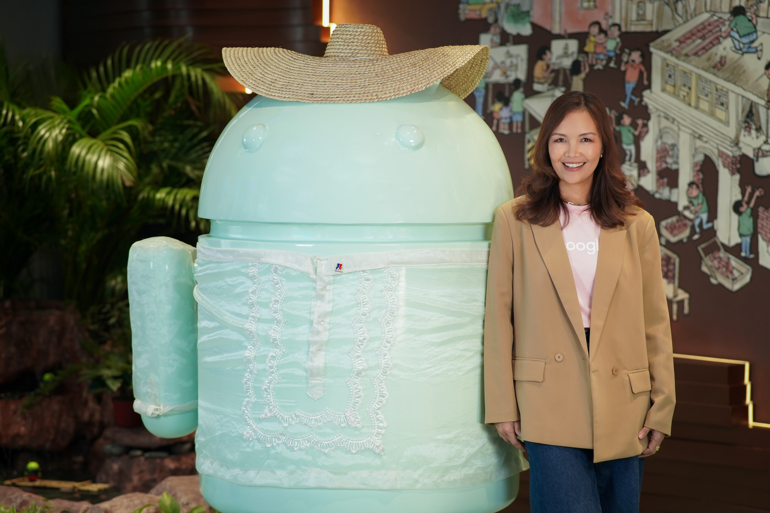 Prep Palacios, Google Philippines' new Country Manager, strikes a pose behind a huge, light green statue of a robot