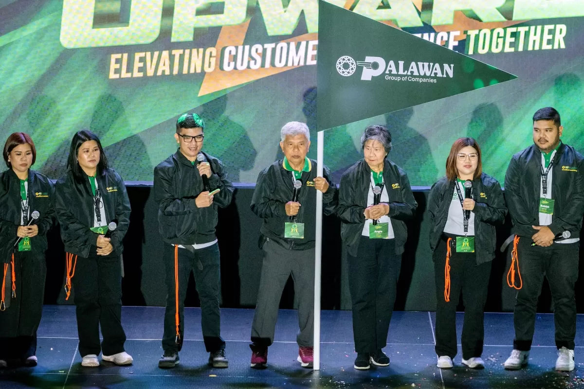 Top executives of Palawan Group led by Bobby L. Castro (holding flag), Founder and Chairman, lead the others in guiding the organization to new heights