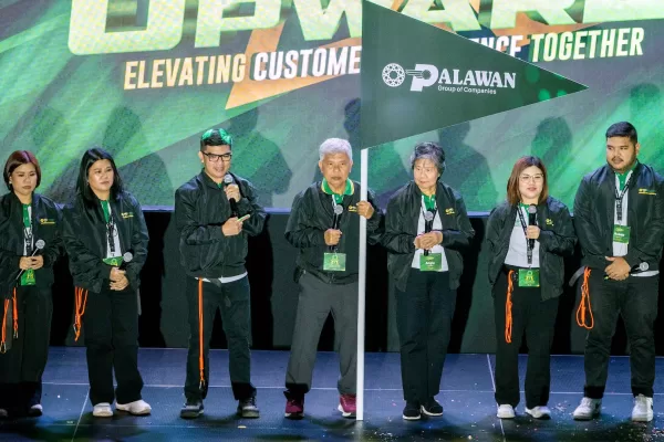 Top executives of Palawan Group led by Bobby L. Castro (holding flag), Founder and Chairman, lead the others in guiding the organization to new heights