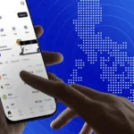 A mobile phone is used here to send money abroad (map of PH in background) as Coins.ph, BCRemit launch Stablecoin-powered remittance corridor to cut costs for OFWs