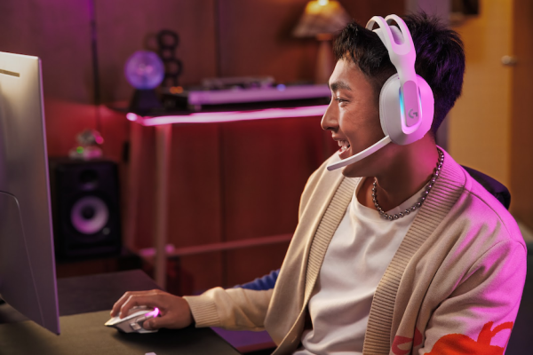 A man using the new Logitech G522 gaming headset smiles after getting leveled up play