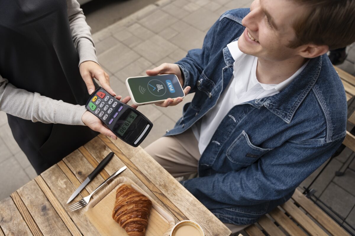 A man paying his bills via his mobile phone using HitPay