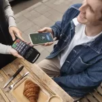 A man paying his bills via his mobile phone using HitPay