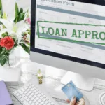 A computer monitor with the words "loan approved" as banks keeping lending standards steady in Q4; Fintech may gain edge in credit flexibility