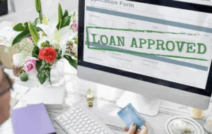 A computer monitor with the words "loan approved" as banks keeping lending standards steady in Q4; Fintech may gain edge in credit flexibility