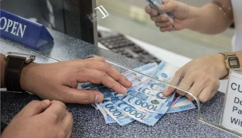 Money being exchanged during a banking transaction as the PH banking sector maintains strong growth as bank lending expands 10.5% in September