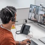 A man with a headset in from of his computer as part of the partner certification program at Fastly to boost security expertise