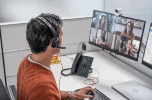 A man with a headset in from of his computer as part of the partner certification program at Fastly to boost security expertise