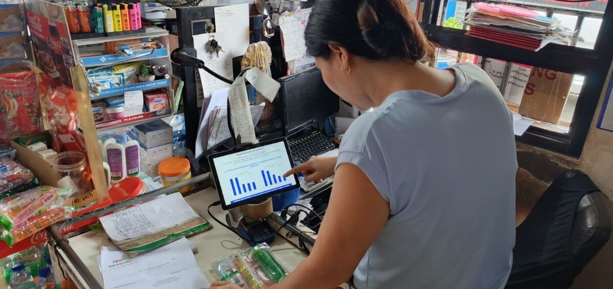 A store owner using AI is used to illustrate Packworks study findings that says AI helps sari-sari stores lift sales by 46%