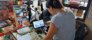 A store owner using AI is used to illustrate Packworks study findings that says AI helps sari-sari stores lift sales by 46%