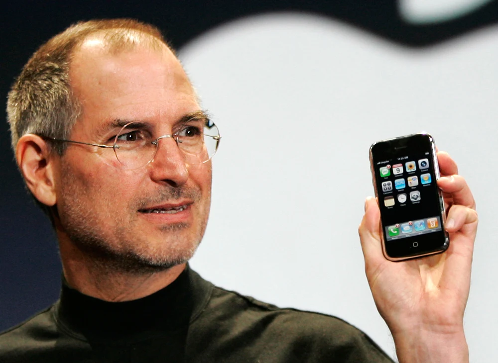 Apple sounds global alarm as spyware threats rise 4 Apple CEO Steve Jobs holding an older iPhone model.