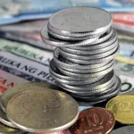 A pile of coins on top of PH bills as BSP surveys show widening confidence gap between businesses and consumers in Q4 2025