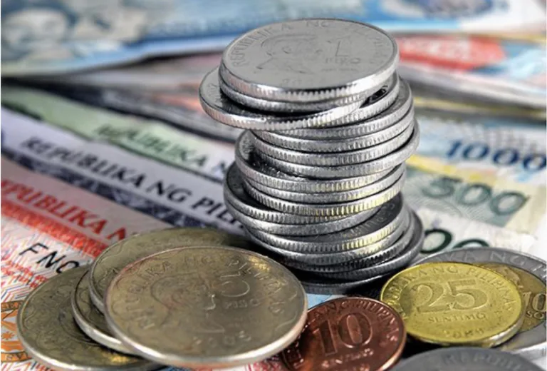 A pile of coins on top of PH bills as BSP surveys show widening confidence gap between businesses and consumers in Q4 2025