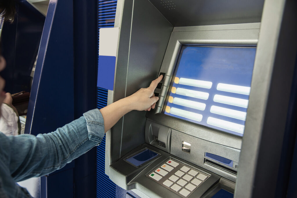 People waiting to get money from automated teller machine 