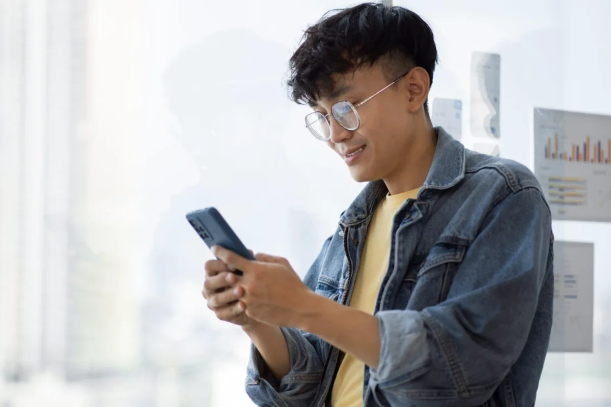 Image of a man holding a mobile phone to show how credit card rewards are reshaping Filipino spending