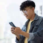 Image of a man holding a mobile phone to show how credit card rewards are reshaping Filipino spending