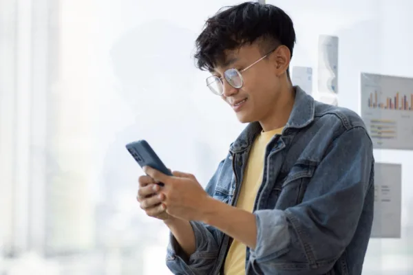 Image of a man holding a mobile phone to show how credit card rewards are reshaping Filipino spending