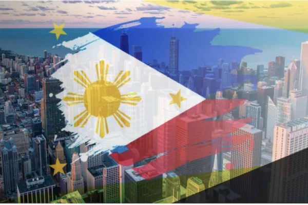 Image of a Philippine flag on top of tall buildings as the BSP sees 2025 inflation within target