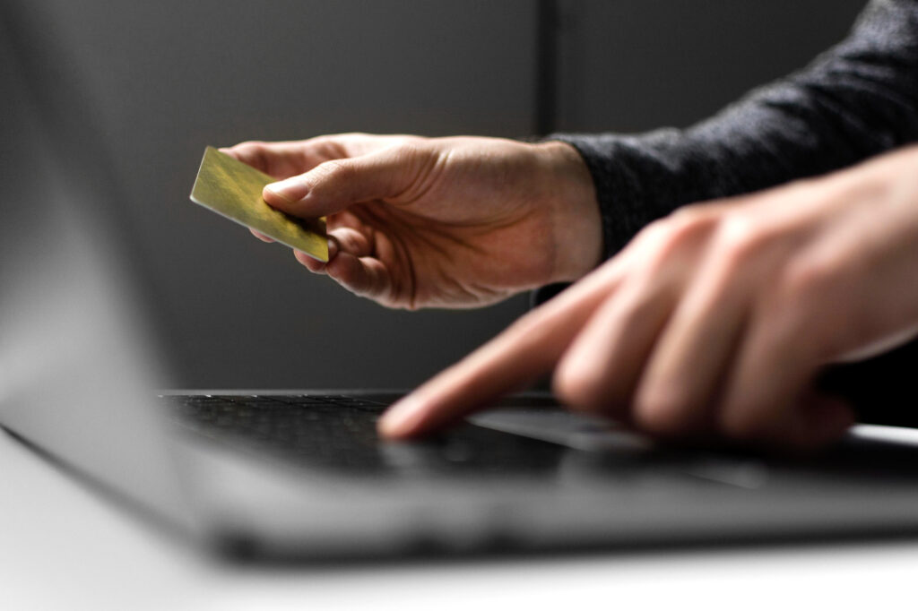 Hacker with a laptop and a golden credit card